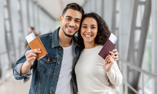 Happy Travellers. Portrait Of Young Arab Couple With Passports And Tickets Posing At Airport, Cheerful Smiling Middle Eastern Spouses Enjoying Travelling Together, Ready For Vacation Trip, Closeup